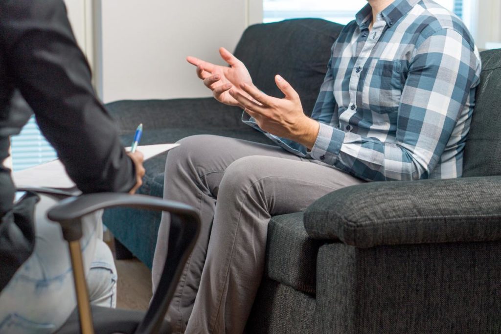 a man opens up in an addiction therapy program as part of his full addiction treatment plan in a men's rehab facility