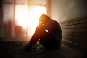 a young man struggles in a dim room with the side effects of cocaine withdrawal